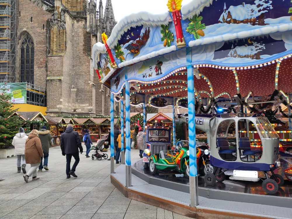 ein buntes Karussell mit verschiedenen typischen Fahrzeugen auf dem Markt.
