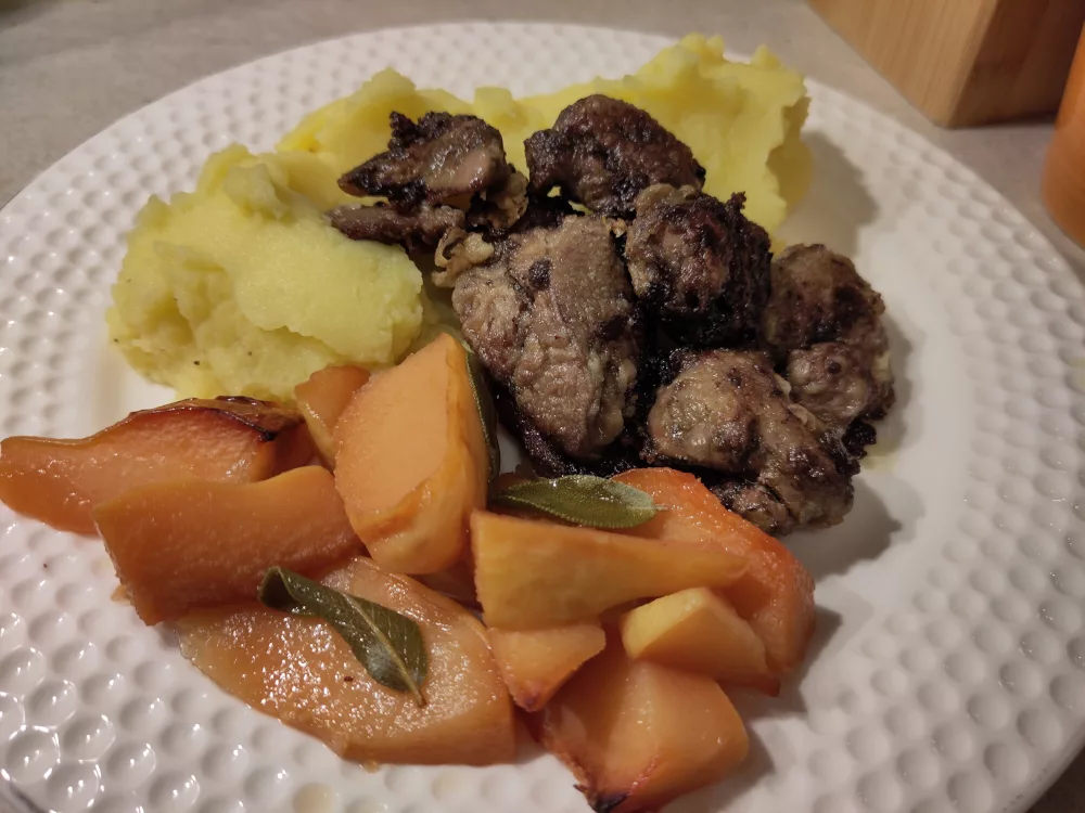 Eine Portion der gebratenen Hühnerleber mit Kartoffelstampf und geschmorten Quitten