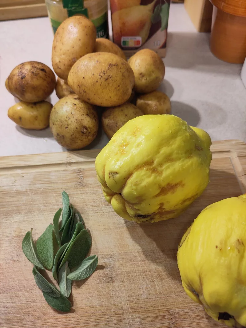 Ein Foto der Zutaten für das Kochen heute, darunter Quitten, frische Salbeiblätter, Kartoffeln und im Hintergrund Honig und Birnensaft.