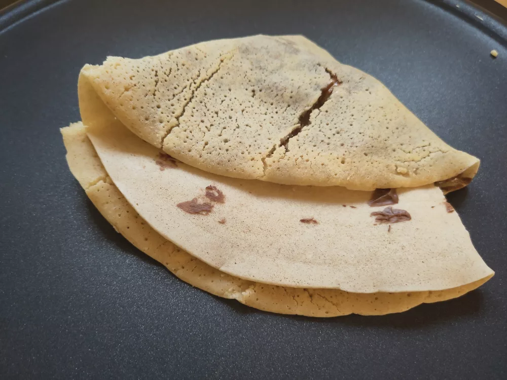 Die noch freie Teighälfte wurde über die belegte Hälfte des Crepe geklappt und der entstandene Handkreis wurde zu einem Viertel zusammen geklappt.