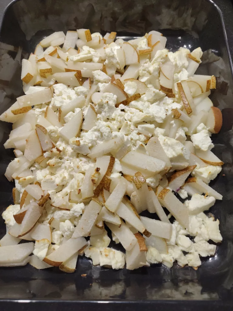 Hirtenkäse und Birnenstücke in einer ofenfesten Form, nachdem beides zusammen kurz im Backofen gegart wurde.