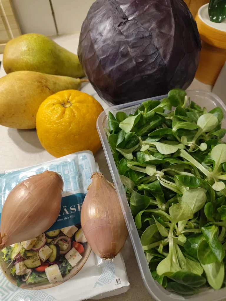 Zutaten für einen Rotkohl Salat: Birnen, Rotkohl, eine Orange, Feldsalat, Schalotten und Hirtenkäse