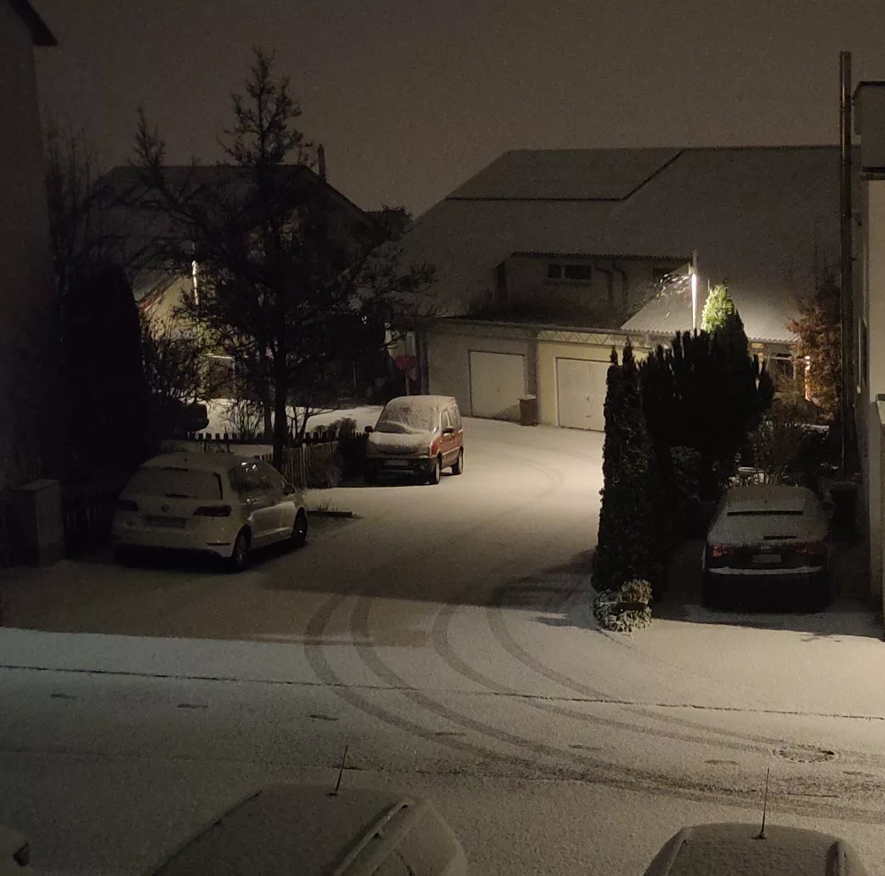 Schneebedeckte Straße bei Nacht.