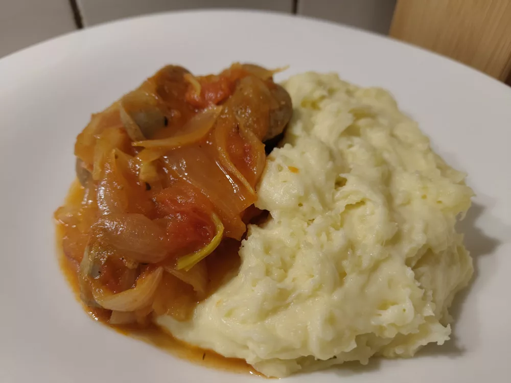 Aligot (französischer cremiger Kartoffelbrei mit Käse) mit Bratwürsten in Schalotten-Tomaten-Sauce