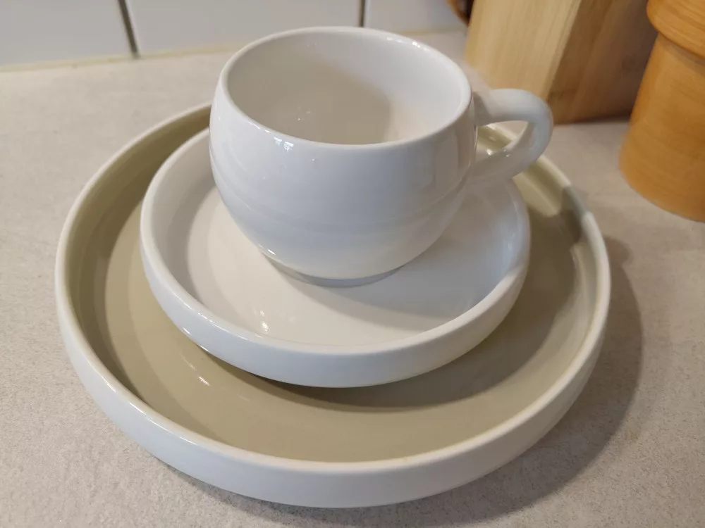 Auf einem kleinen Teller wurde eine Untertasse und eine Tasse gestapelt.