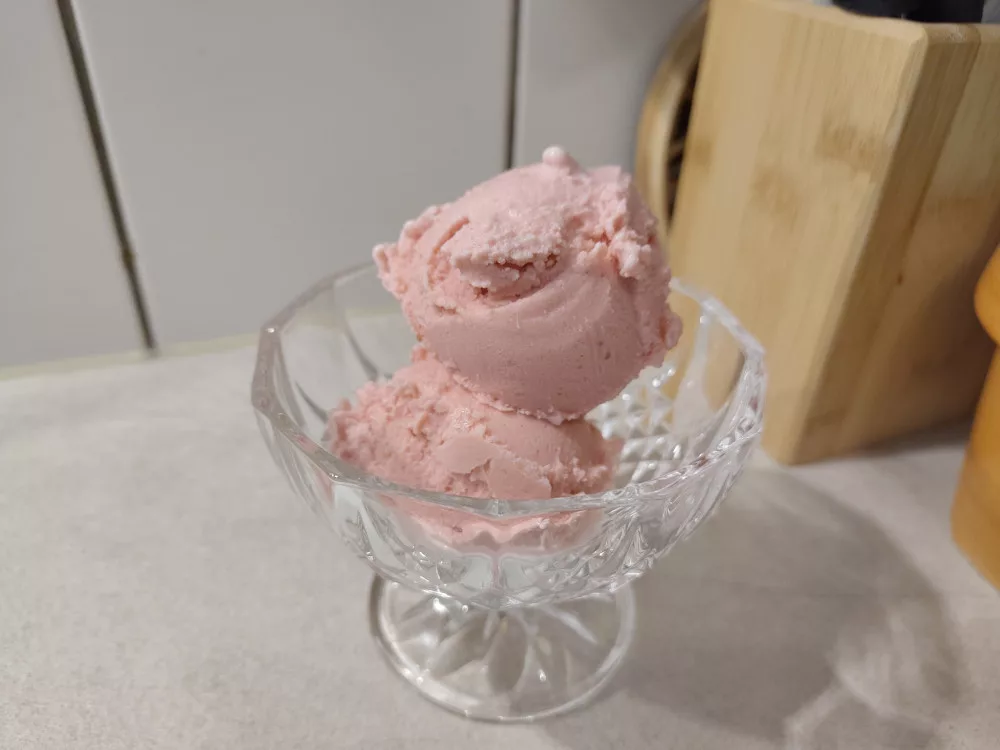 Zwei Kugeln vegane Erdbeer-Eiscreme in einer gläsernen Dessertschale