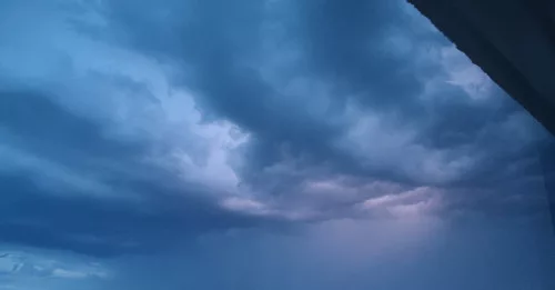 Ein Blitz erhellt die Wolken am Abendhimmel