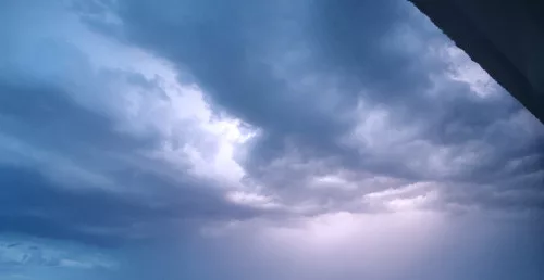 Ein Blitz erhellt die Wolken am Abendhimmel