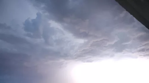 Ein Blitz erhellt die Wolken am Abendhimmel