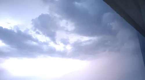 Ein Blitz erhellt die Wolken am Abendhimmel