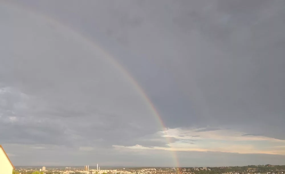 Ein Fotoausschnitt eines Regenbogens vor einem wolkenbehangenen Himmel