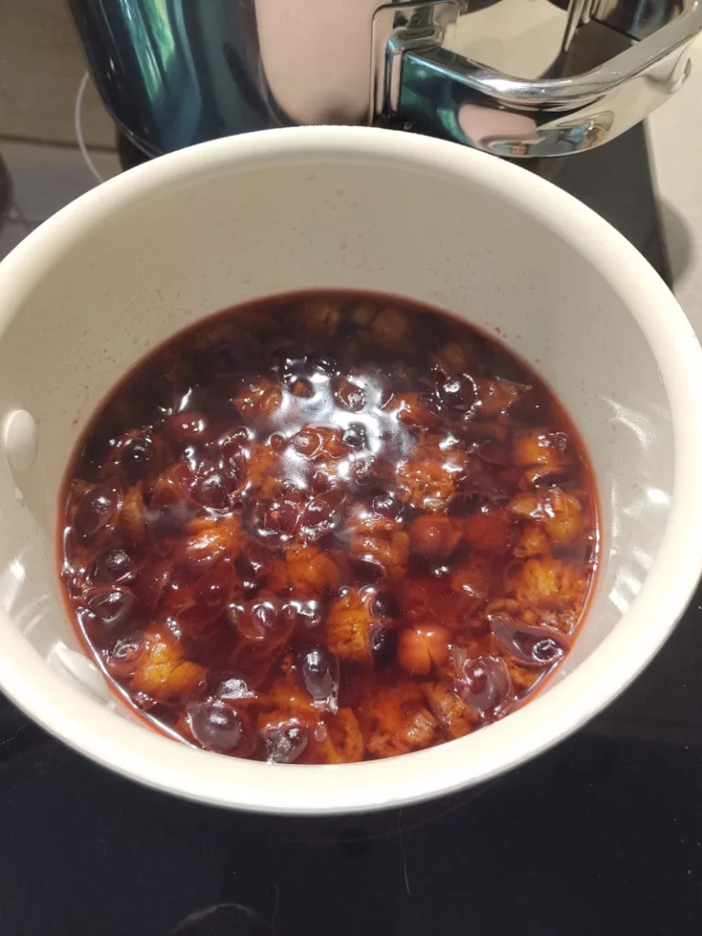 Die Zibarten kochen in einem kleinen Kochtopf mit Fruchtsaft.