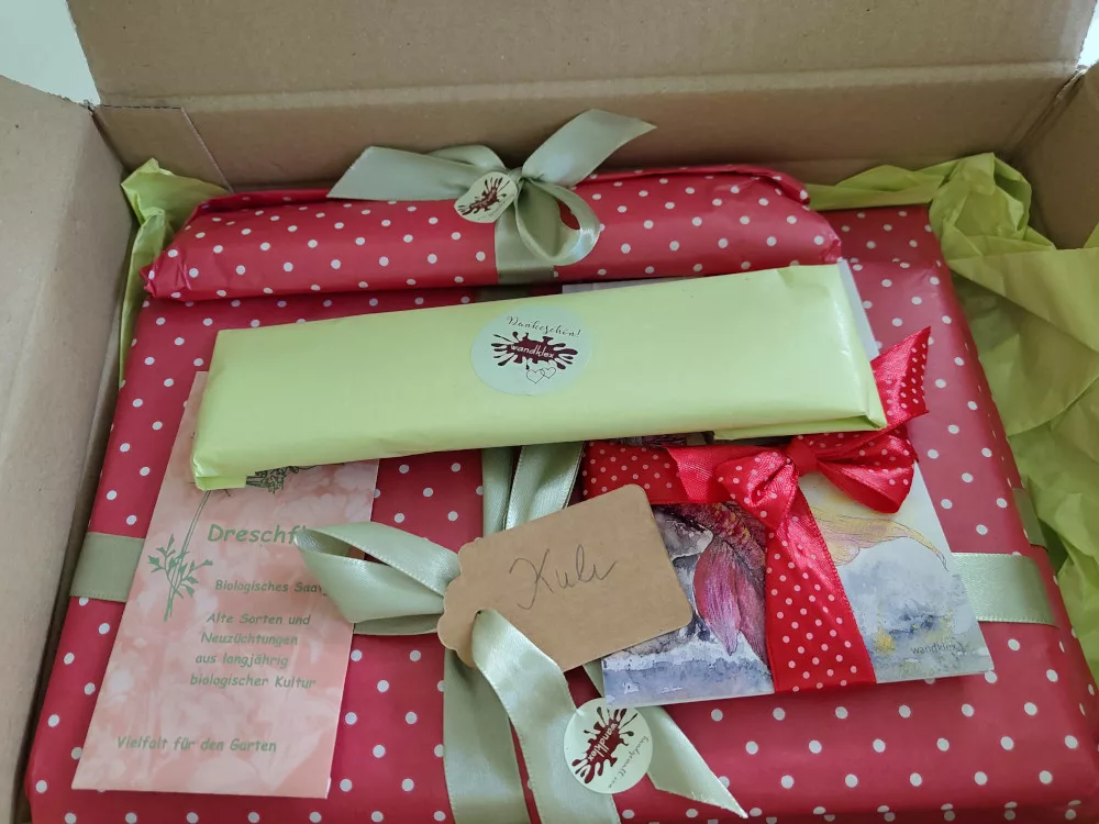 ein liebevoll verpacktes Paket in dem die einzelnen Bestandteile der Bestellung in Geschenkpapier verpackt und mit grünem Seidenband verziert wurden. https://www.wandklex.art/