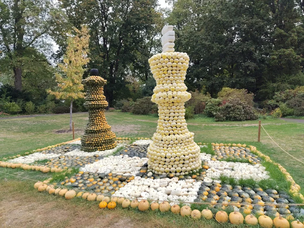 Zwei Schachfiguren auf einem Schachbrett, beides gestaltet aus Kürbissen